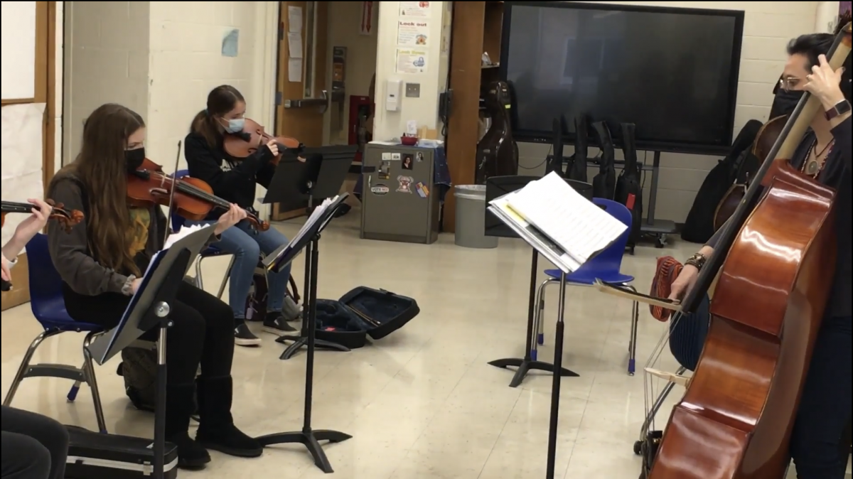 Students play their string instruments with their teacher, Ms. Monica Monica Antonelli-Guido.