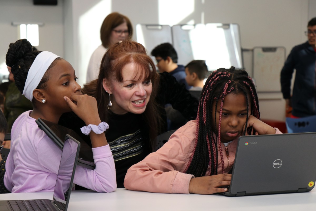 Mrs. Thomas-Cappello works with younger scholars during an Hour of Code event.