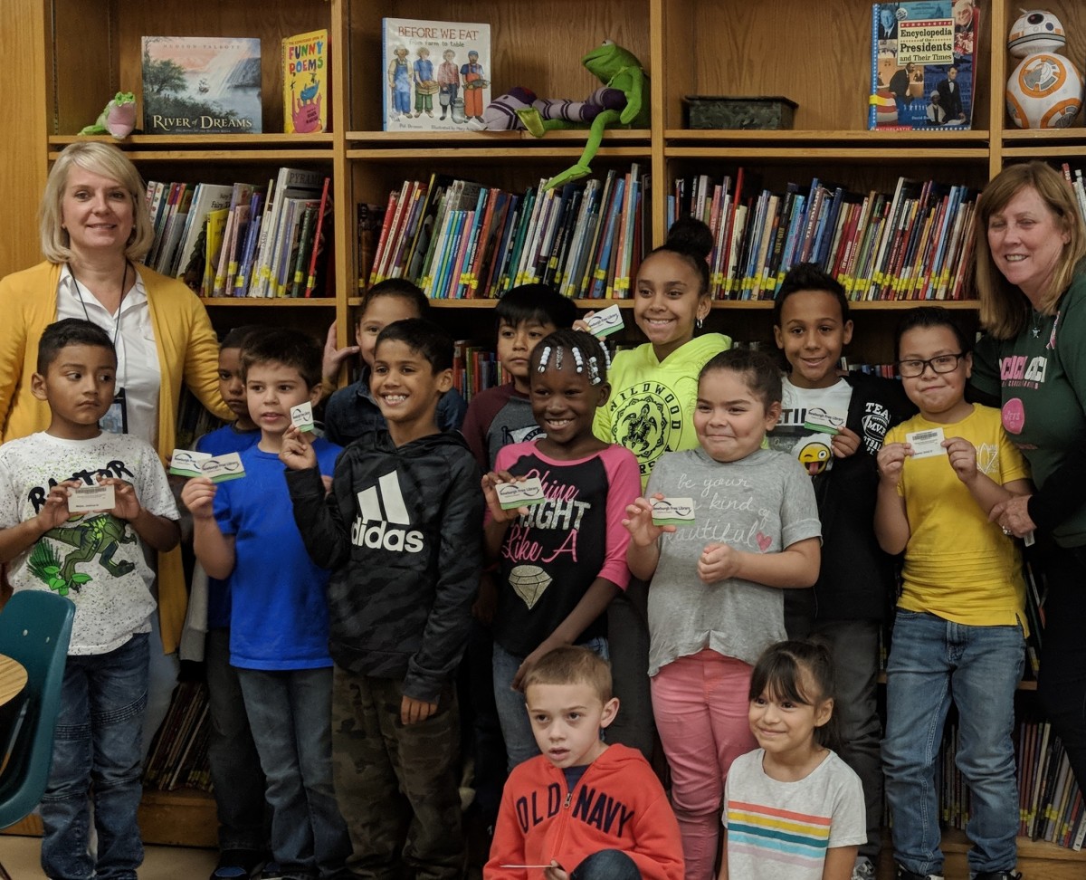 Mrs. Zoutis and Ms. Gilligan stand with students who received their library cards.