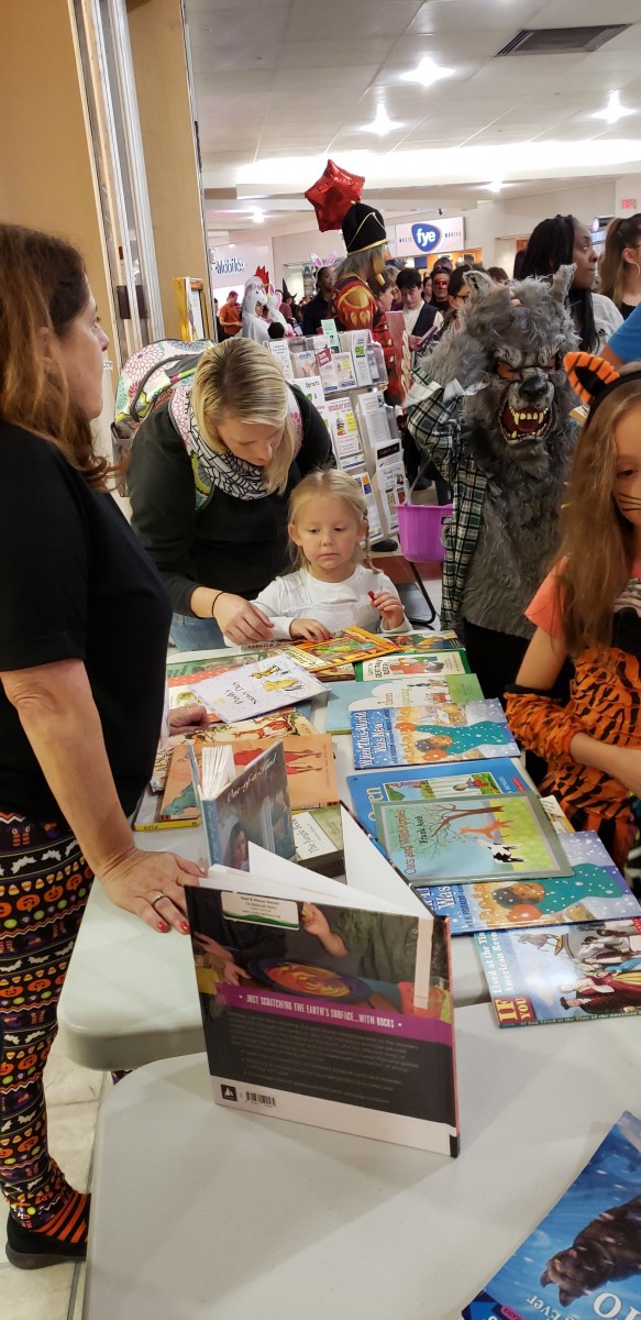 Participates at table of books.