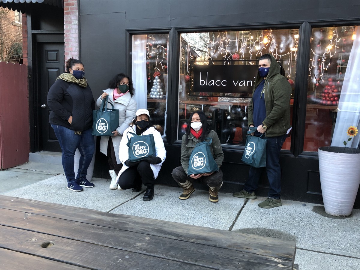 Group of community members with their bags of goods.