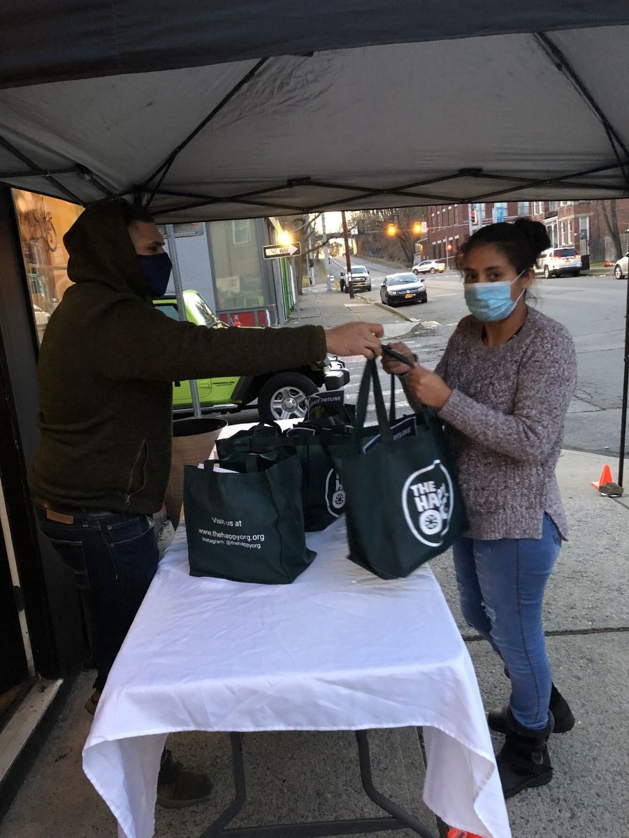 Volunteers pass bag to community member.