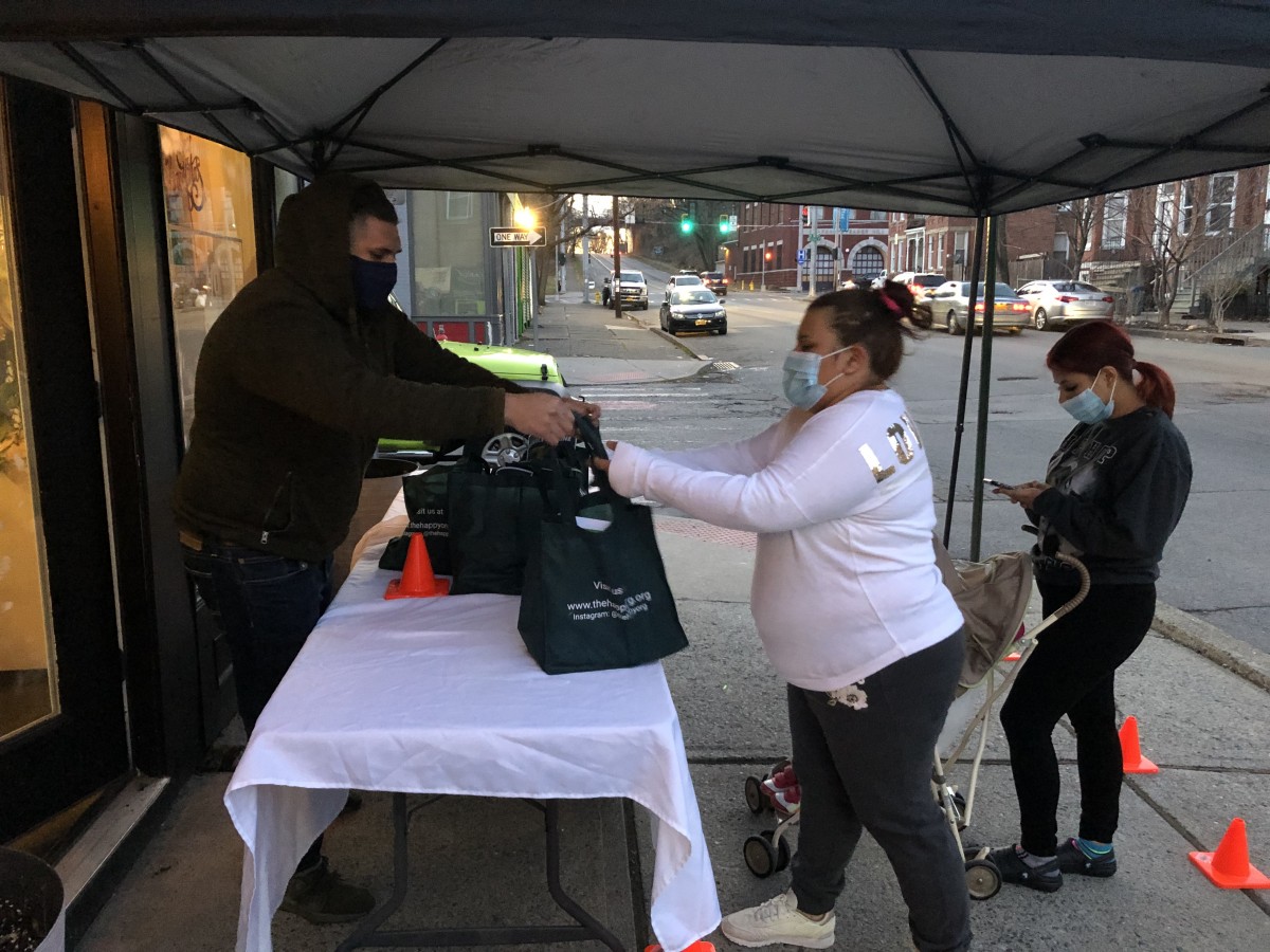 Volunteers pass bag to community member.