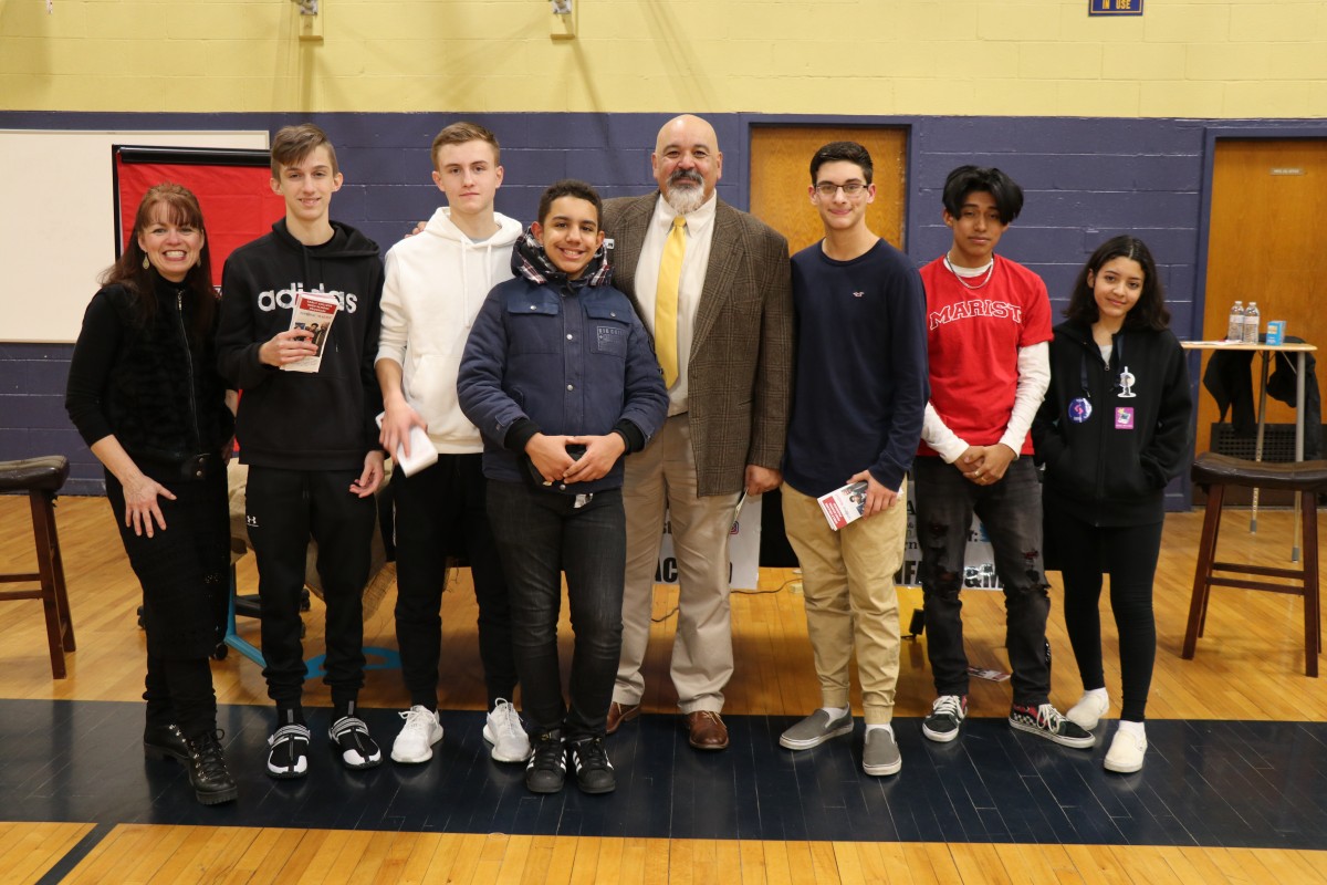 Scholars pose for a  photo with building principal Mr. Raul Rodriguez.