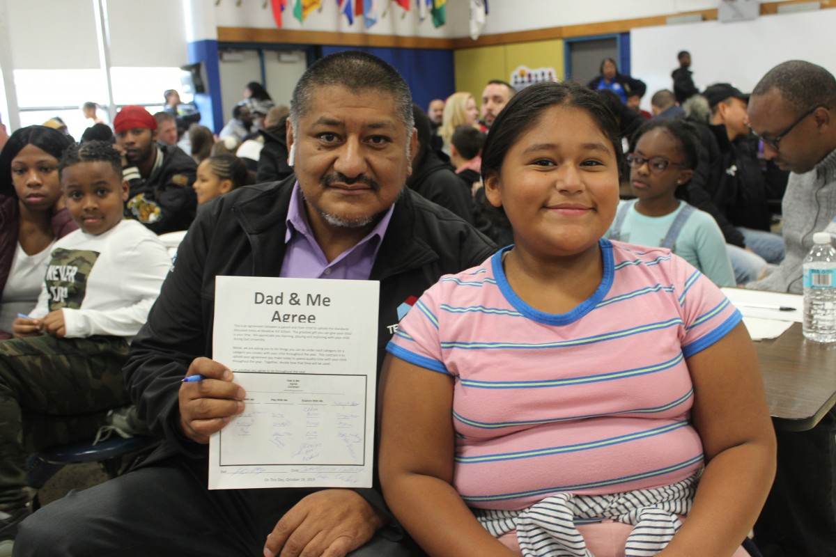 Father and child pose for photo.