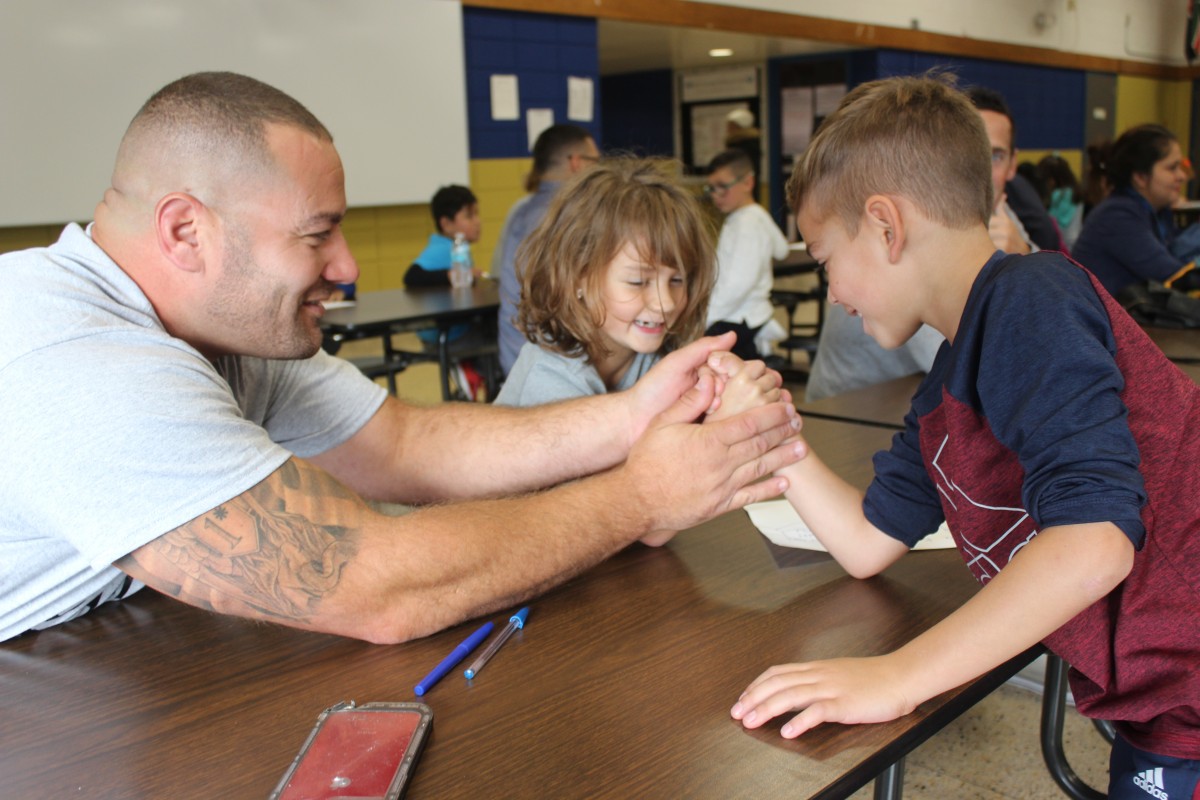 Father and child arm wrestling.