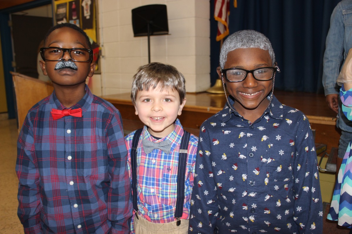 Students pose for a photo wearing costumes of a 100 year old.