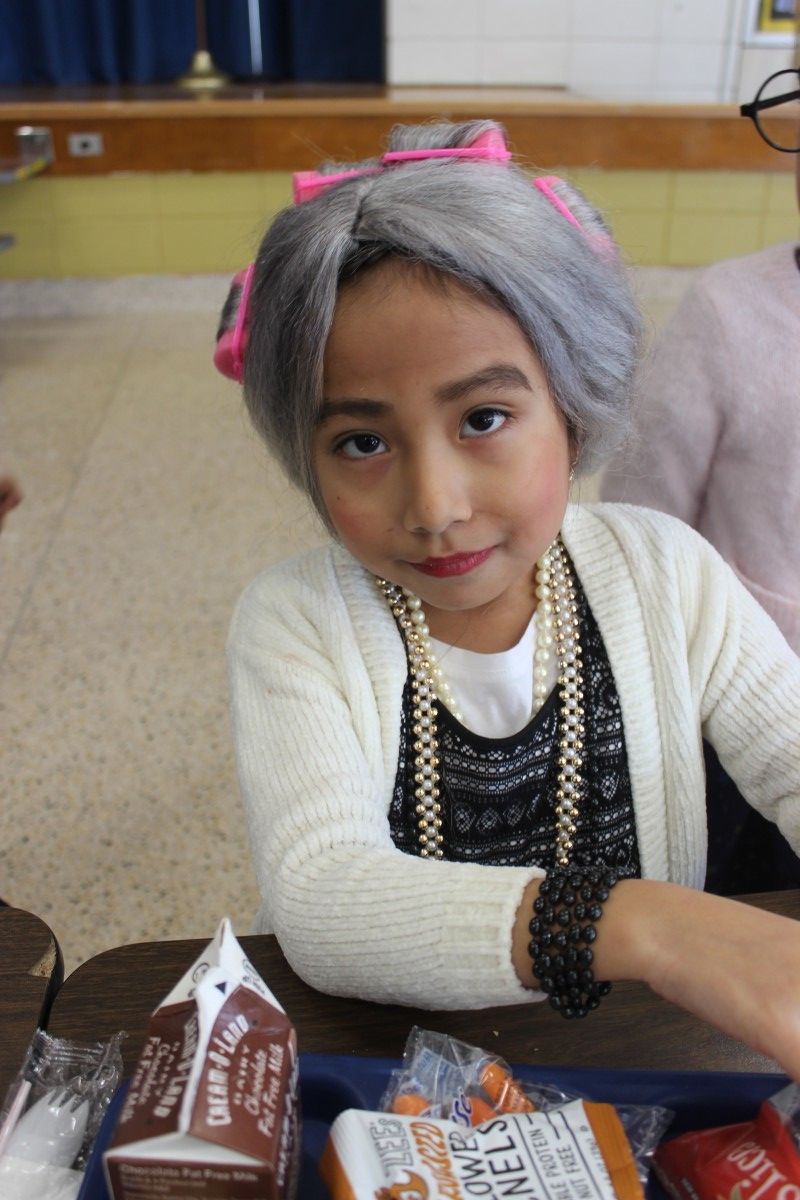 Students pose for a photo wearing costumes of a 100 year old.