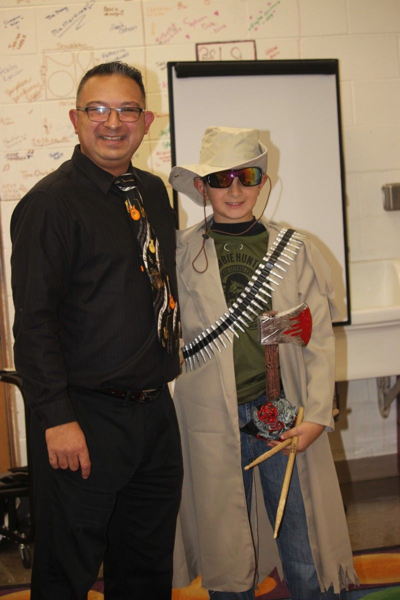 Student poses in costume with their teacher.