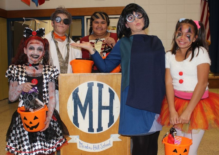 Students pose in costume with their teacher.