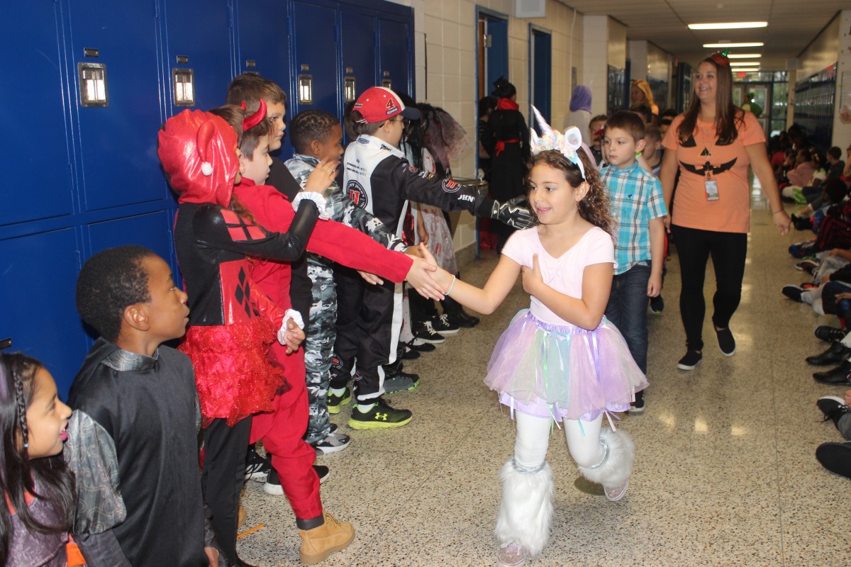 Students participate in hallway Halloween parade.