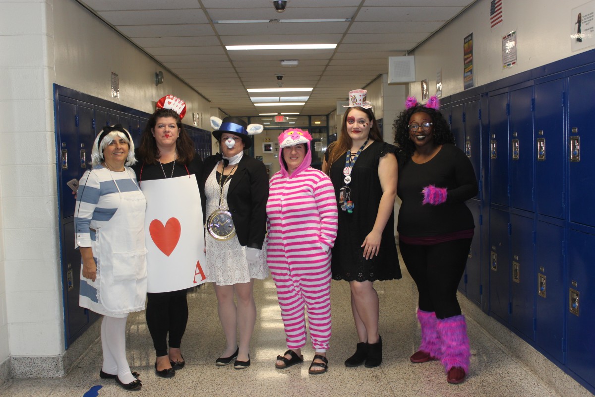 Teachers pose in their Alice in Wonderland costumes.