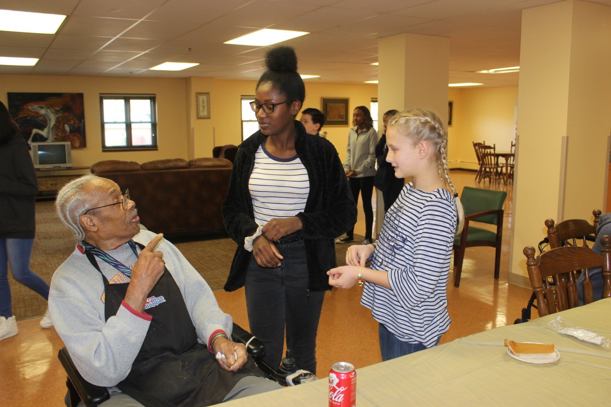 MHS volunteers handing out food and conversing with residents.