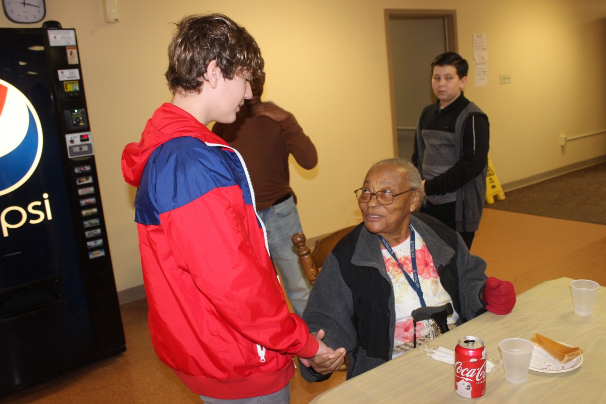 MHS volunteers handing out food and conversing with residents.