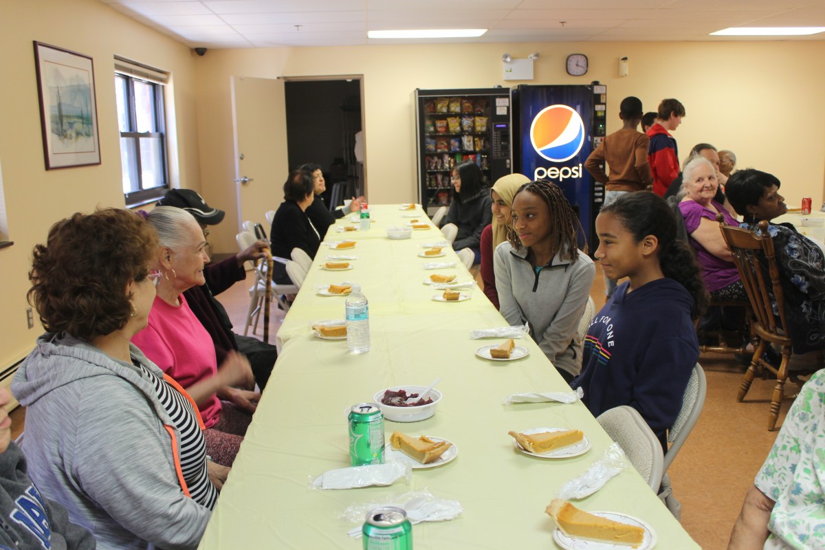 MHS volunteers handing out food and conversing with residents.