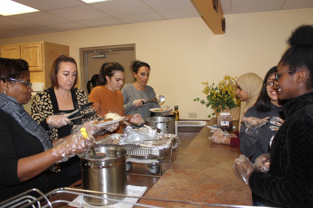 MHS volunteers handing out food and conversing with residents.