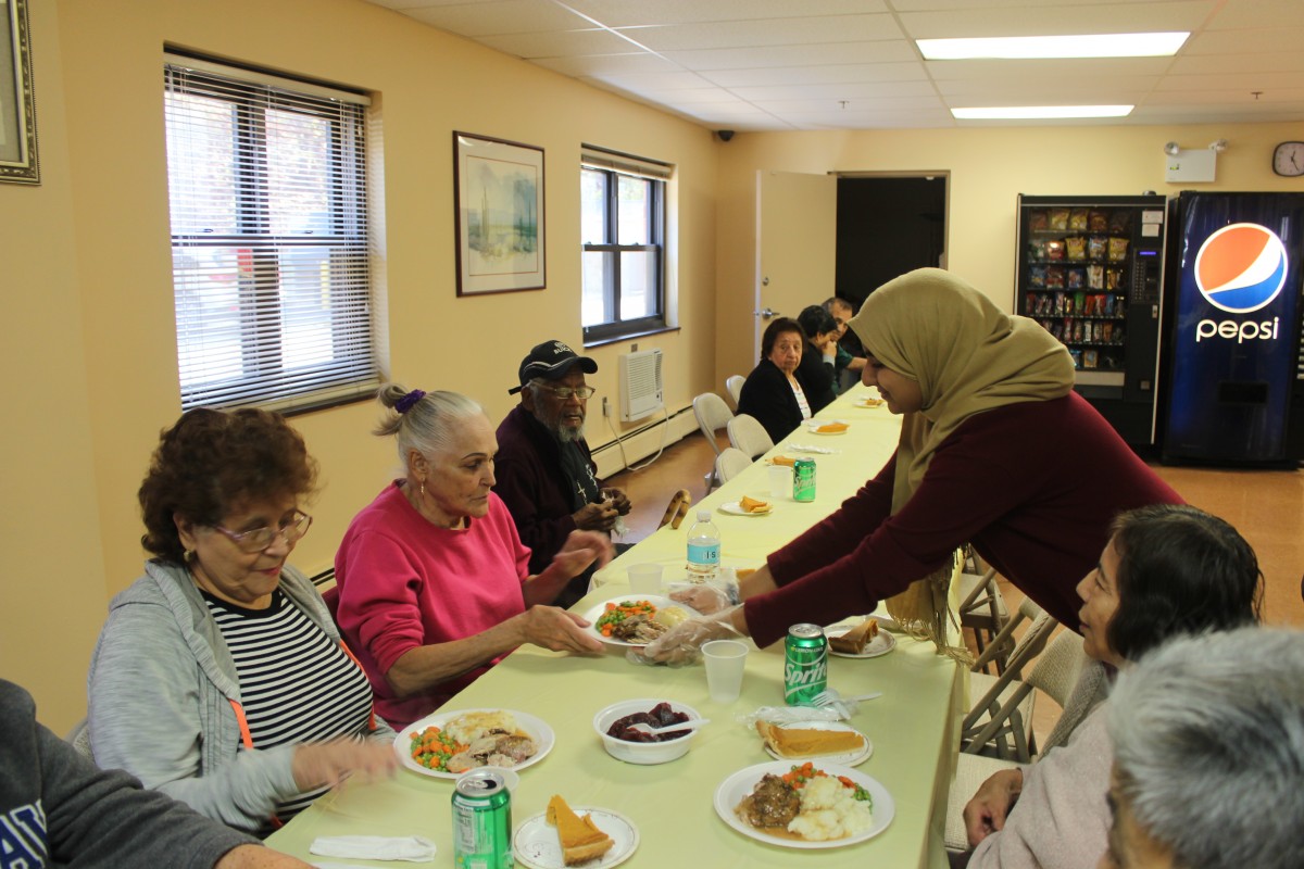 MHS volunteers handing out food and conversing with residents.