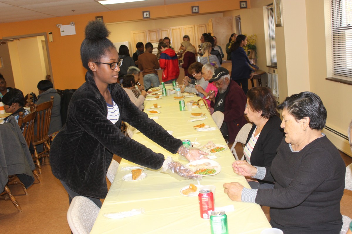 MHS volunteers handing out food and conversing with residents.