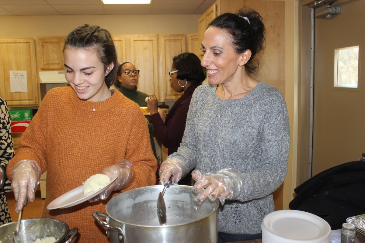 MHS volunteers handing out food and conversing with residents.