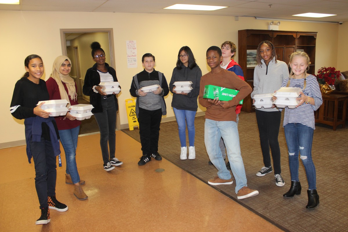 MHS volunteers handing out food and conversing with residents.