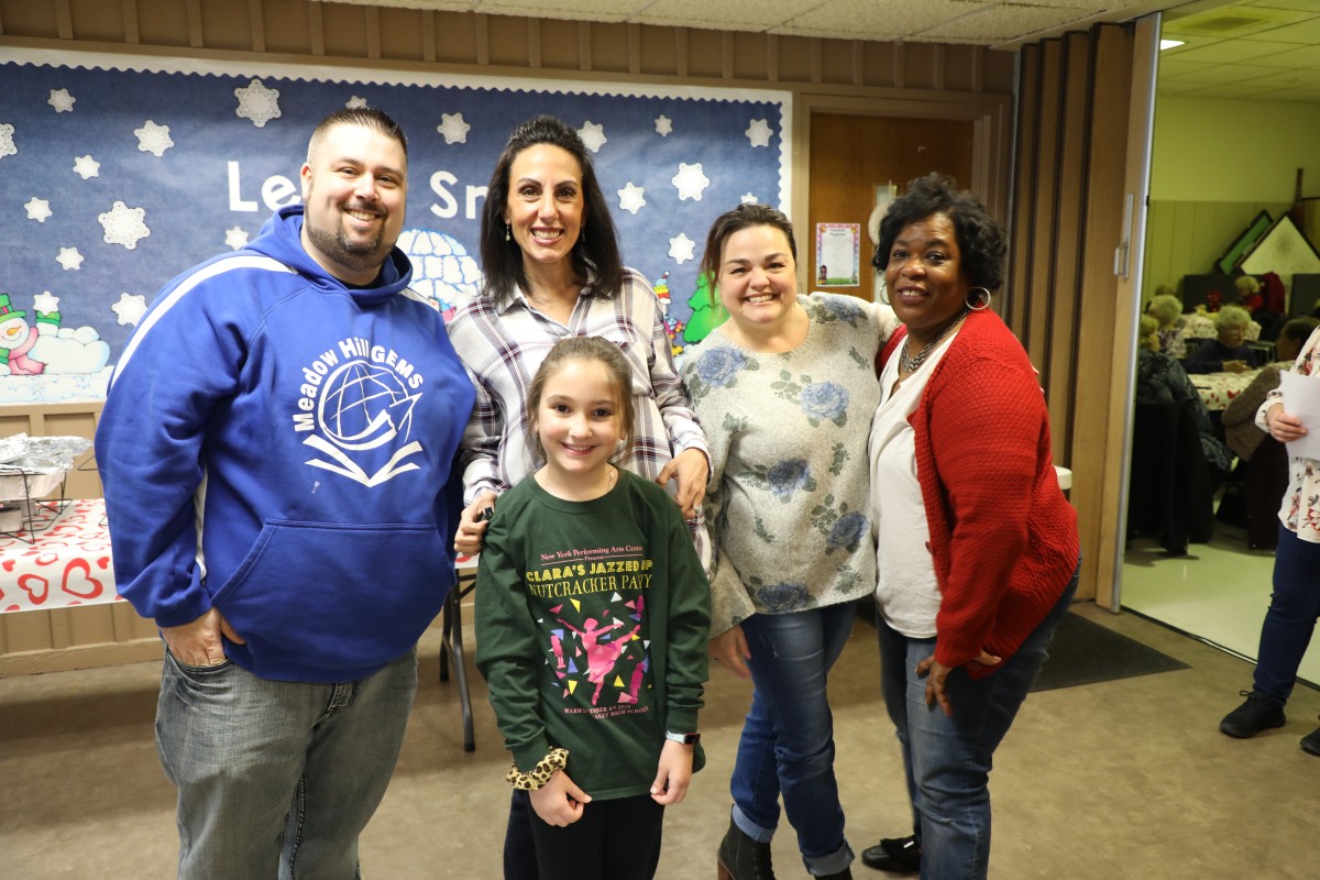 Volunteers pose for a photo with the building principal.