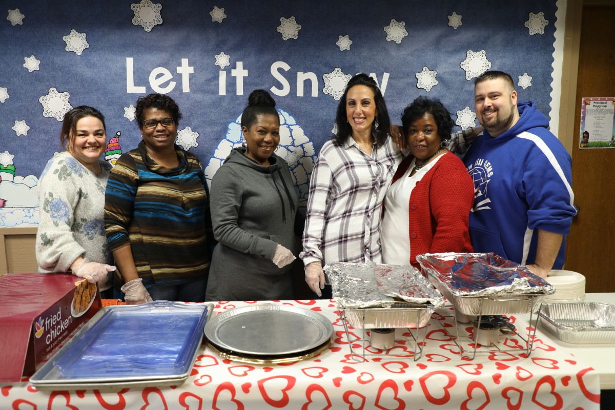 Volunteers pose for a photo with the building principal.