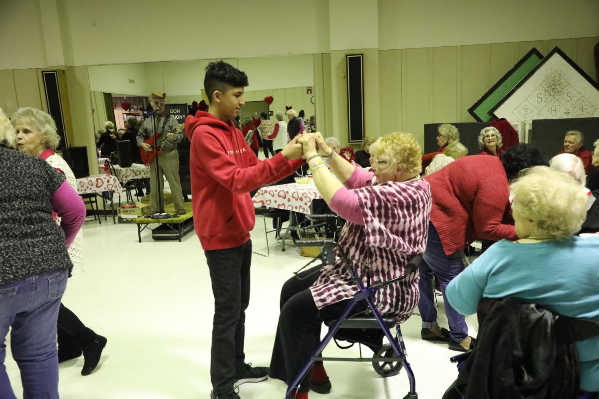 Student dances with a senior guest.