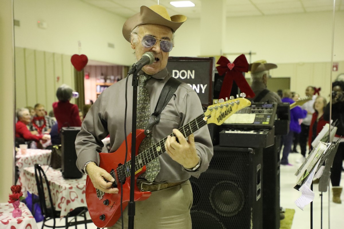 Performer sings with a guitar.