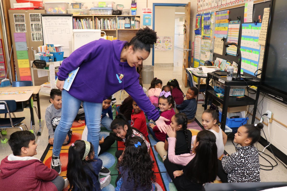 High school scholar greets first graders with high fives.