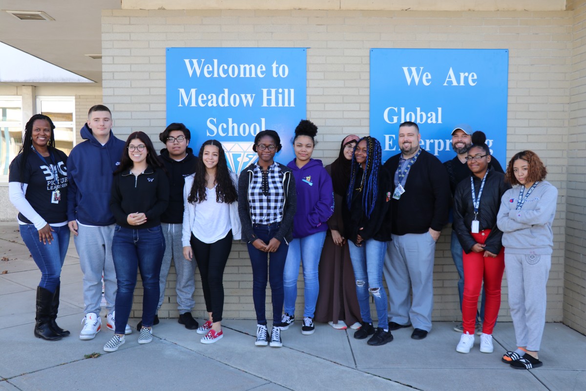 Group of high school scholars, Meadow Hill principal, and their guidance counselor pose for a photo.