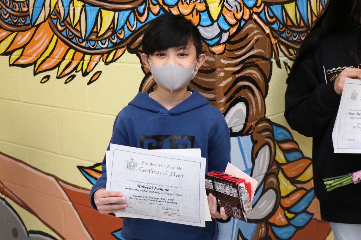 Student holding up certificate.