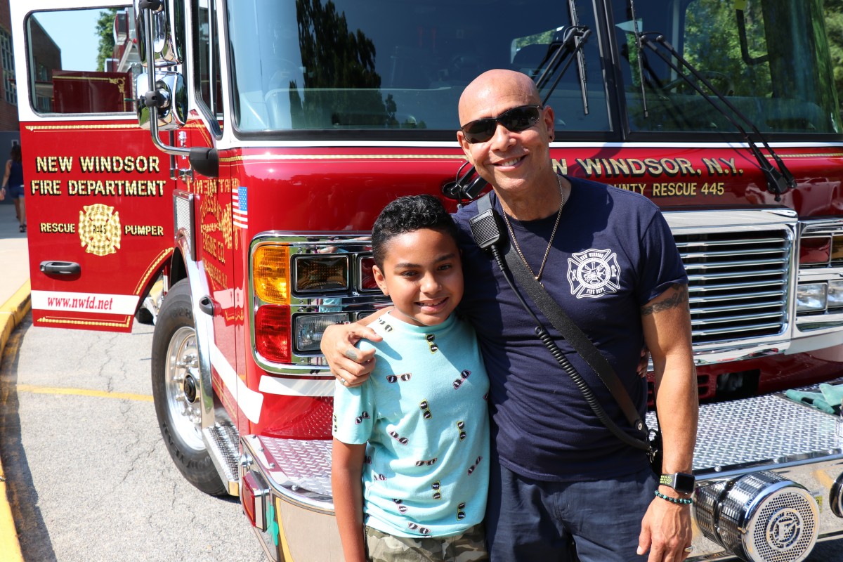 Student poses with firefighter.