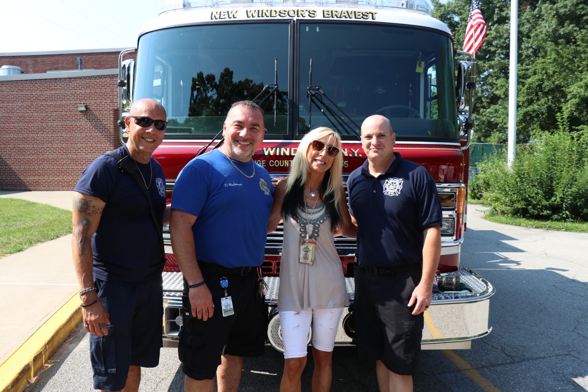 Firefighters pose with teacher and security guard.