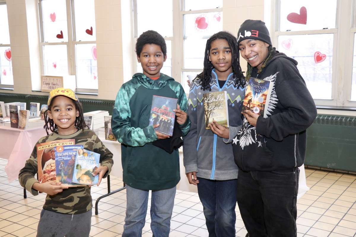 Family poses with new books from the event