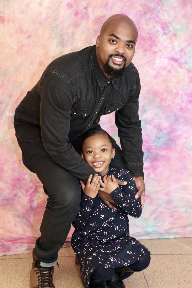 School Counselor, Mr. Kareem Donaldson poses with his daughter at the photo booth