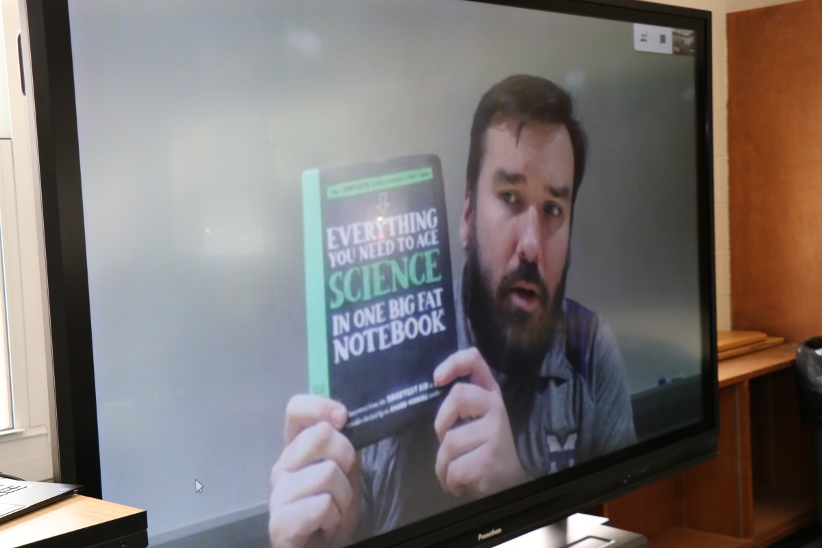 Presenter shows new textbook.