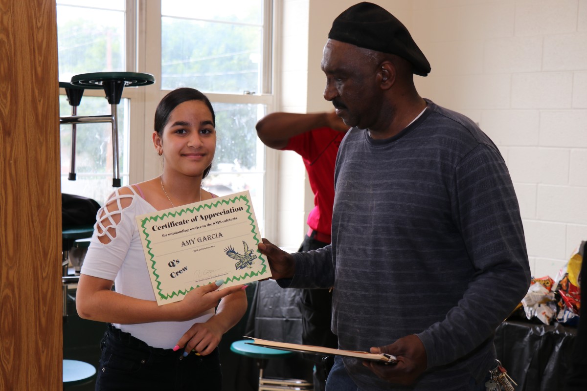 Student receives certificate from Mr. Q.