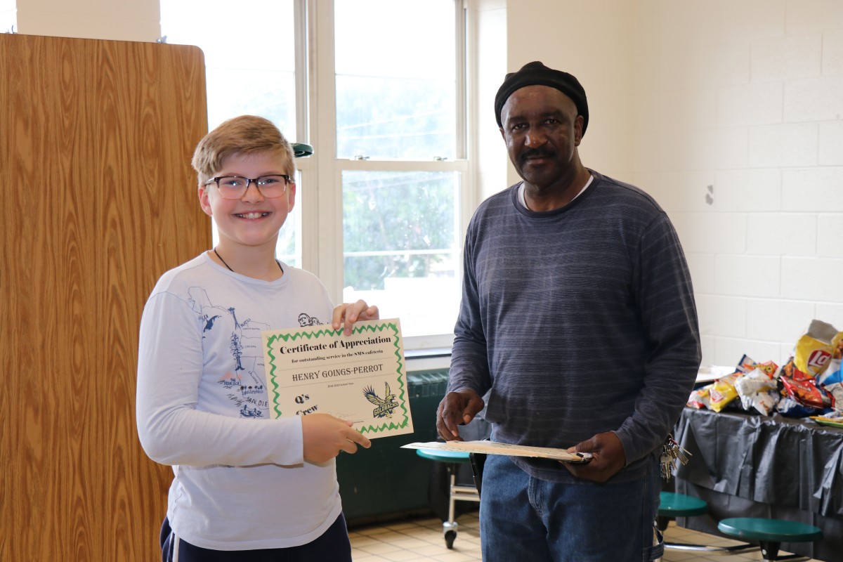 Student receives certificate from Mr. Q.