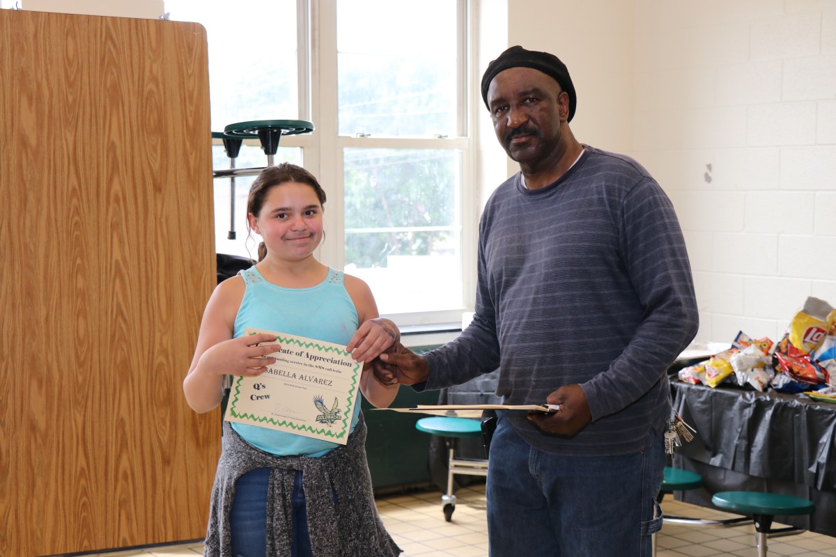 Student receives certificate from Mr. Q.