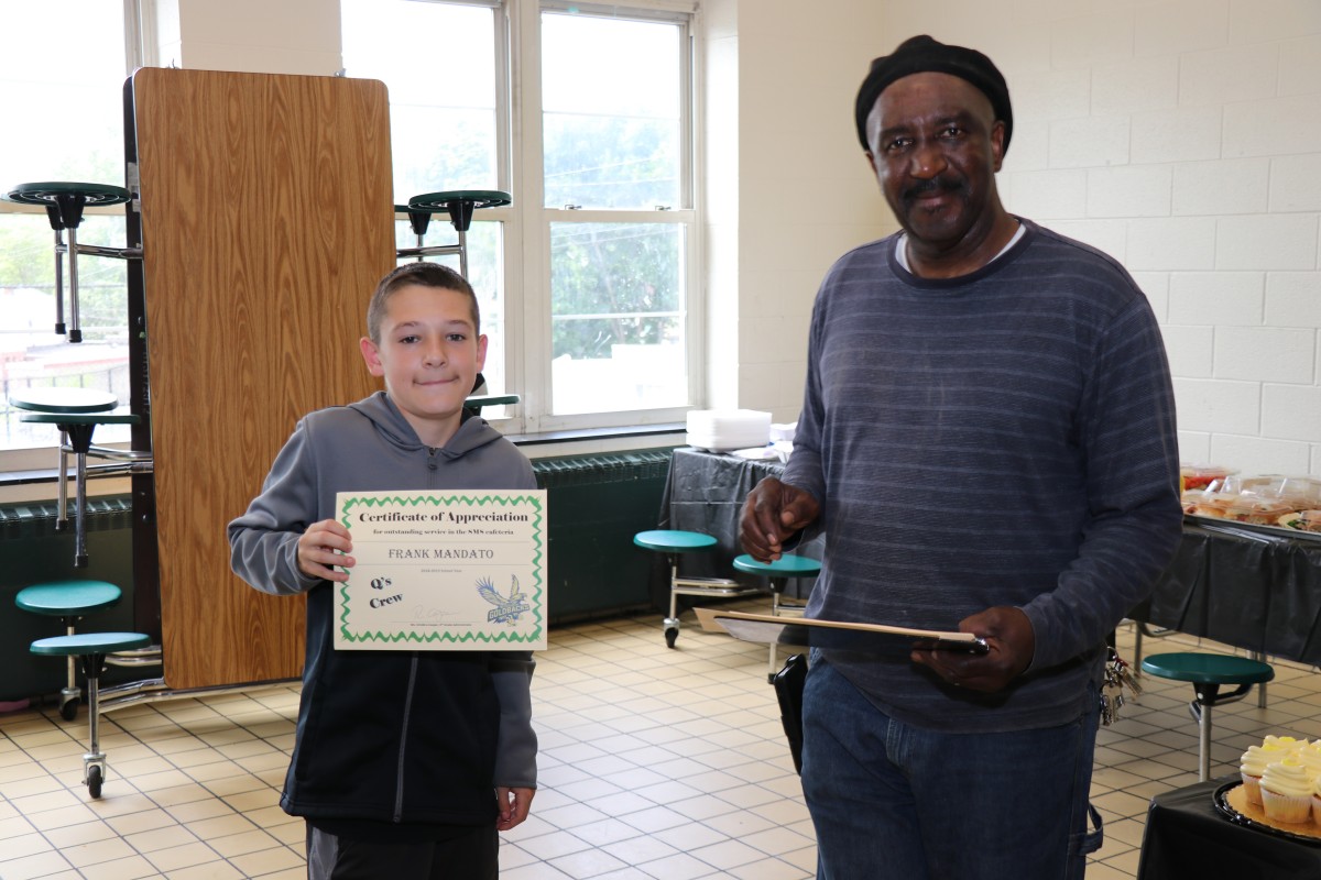 Student receives certificate from Mr. Q.