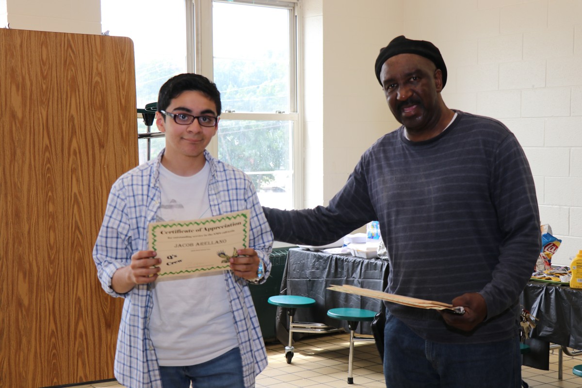 Student receives certificate from Mr. Q.