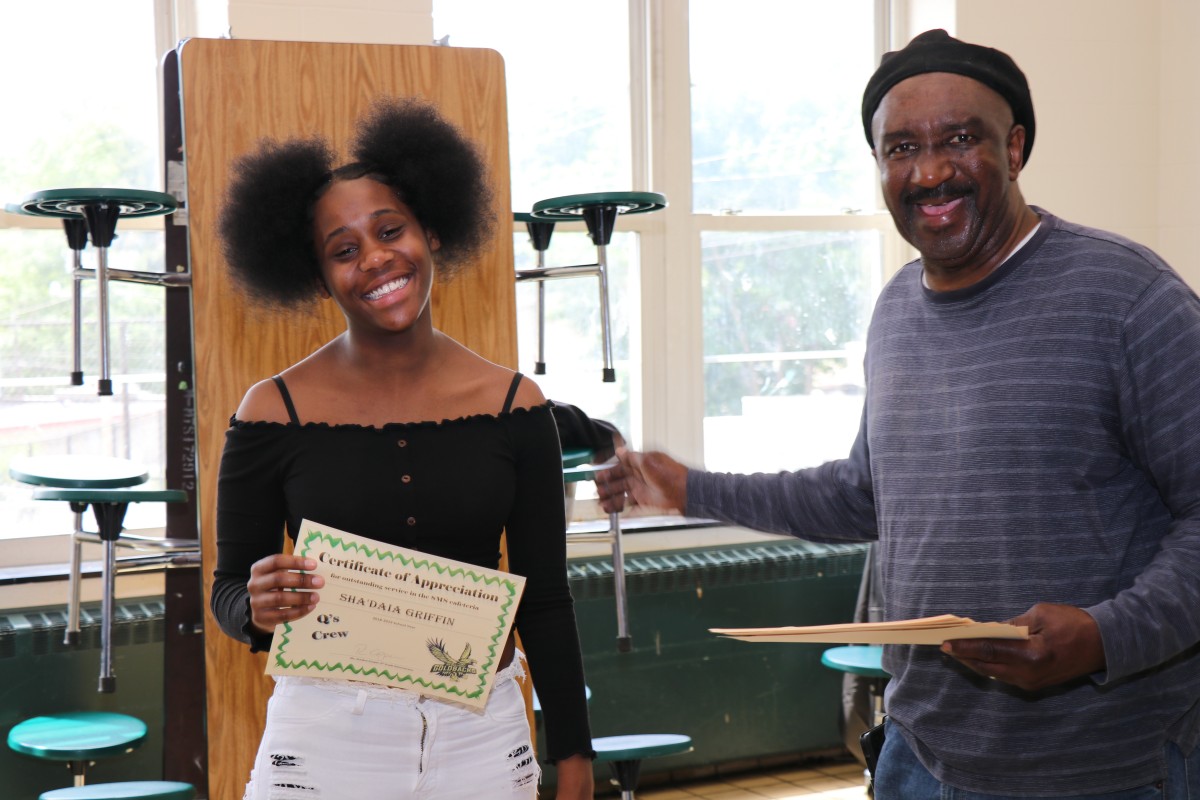 Student receives certificate from Mr. Q.