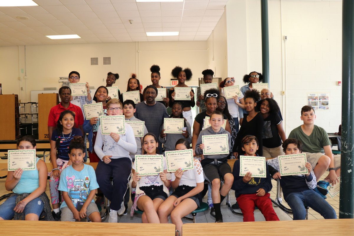 The students sit for a group picture with Mr. Q.