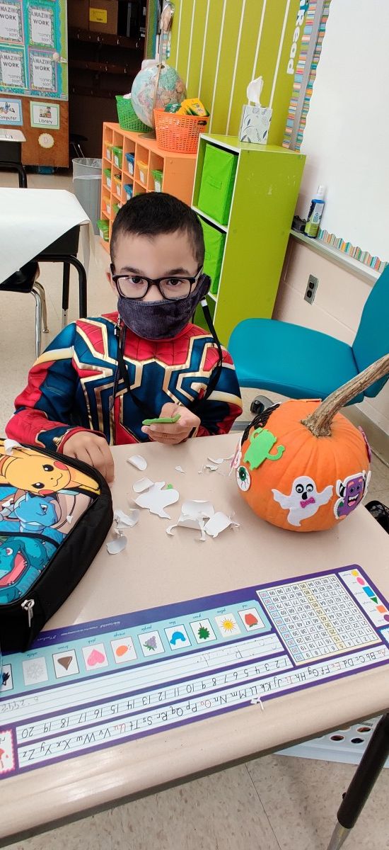 Students decorating pumpkins in classroom.