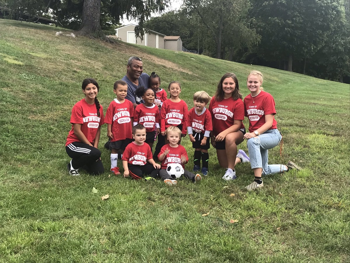 Volunteer coaches pose with their young athletes.