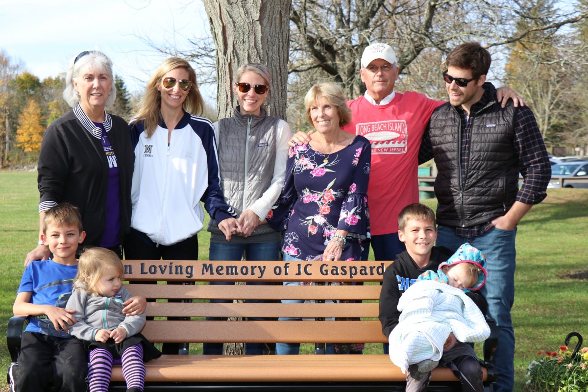 The Gaspard family stands for a photo near the bench.