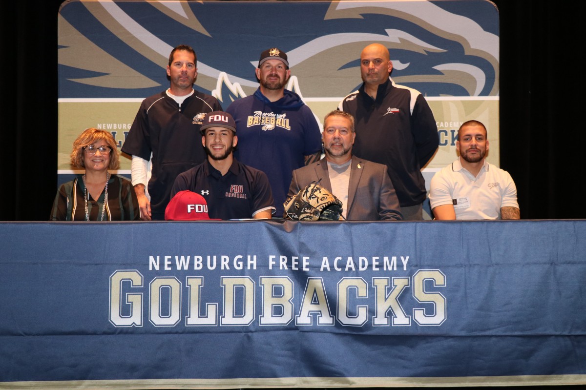 Lucas poses for a photo with his parents and coaches.