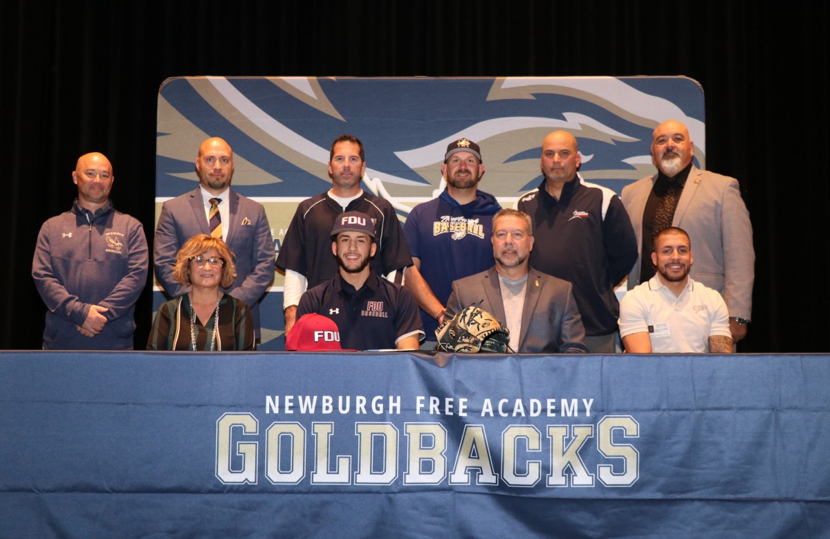 Lucas poses for a photo with his parents, coaches, and administrators.