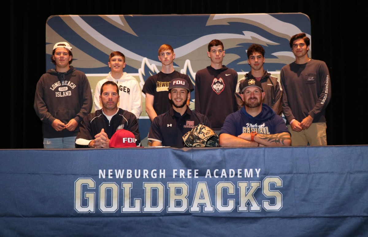 Lucas poses for a photo with friends/teammates and coaches.