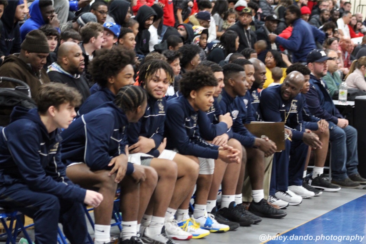 Teammates looking on from the bench.